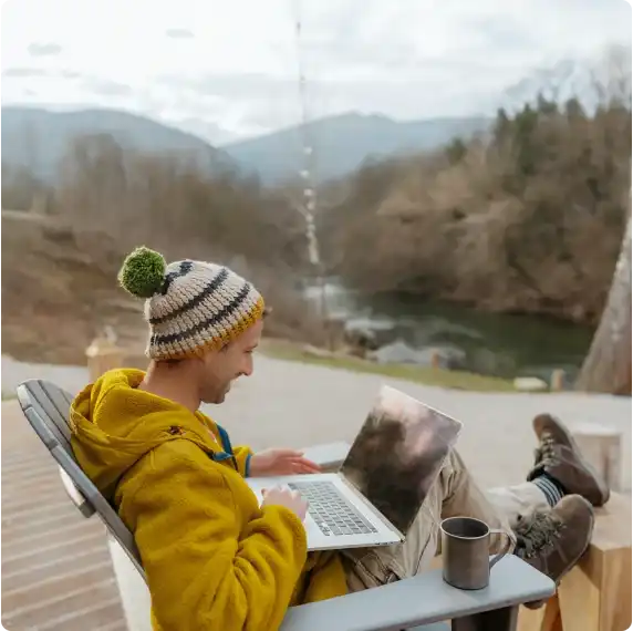 A person woking on their laptop outdoors.