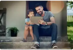 A father and son using a tablet outdoors