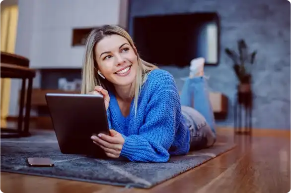 A woman laying on the floor using her tablet