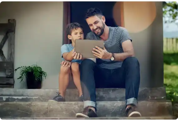A father and son using a tablet outdoors