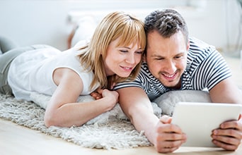Young couple on bed using tablet device together