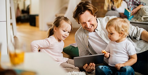 Father with two small children playing on ipad