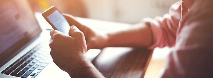 Image of man on phone and laptop