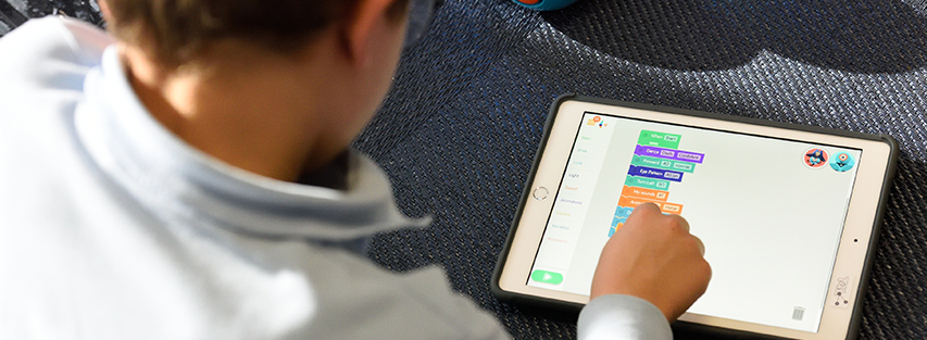 Child coding on tablet