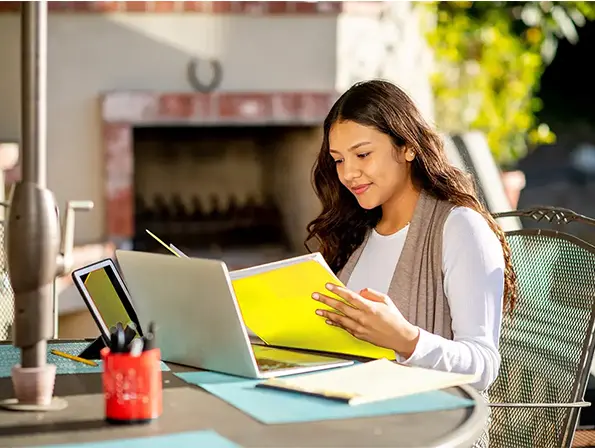 girl looking at folder and working on her porch using Hughesnet