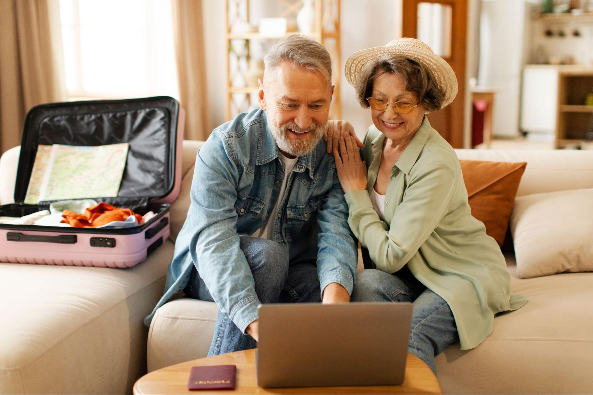 An old couple looking at a laptop together
