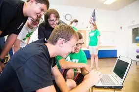 students gathered around a laptop