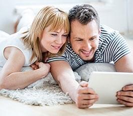 Image of couple using tablet benefiting from HughesNet SmartTechnologies for faster, more efficient Internet Thumbnail