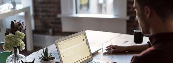 Man working on a laptop at home, relying on Hughesnet satellite internet for a seamless connection.