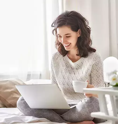 woman drinking coffee using a laptop