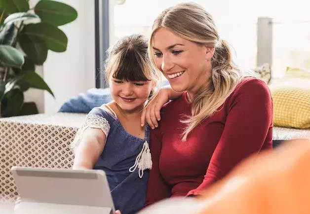mother and daughter browsing internet on ipad