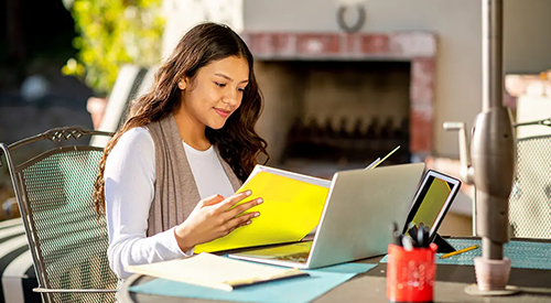 girl using hughesnet satellite internet on her porch to do home work