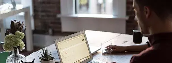 Man working on a laptop at home, relying on Hughesnet satellite internet for a seamless connection.