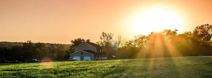 Sunset over a rural home, where Hughesnet satellite internet provides reliable connectivity for remote living.