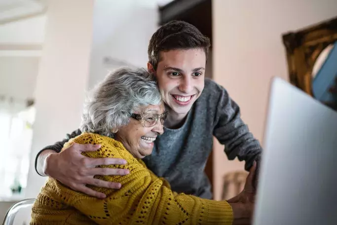 Man and elderly woman using laptop with satellite internet