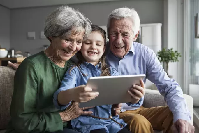 grandparents and grandchild using a mobile tablet
