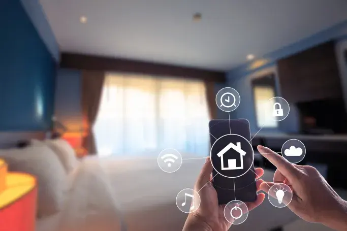 Person using a smartphone to control smart home devices in a modern bedroom, with icons representing features like lighting, Wi-Fi, security, and music.