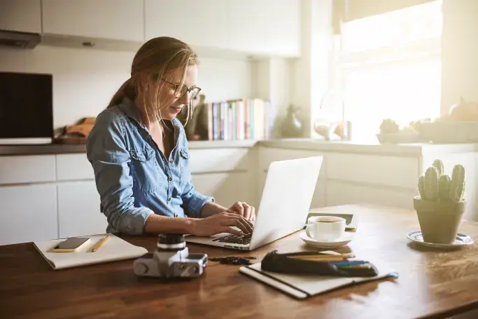Remote worker using a laptop in a bright kitchen, supported by satellite internet.