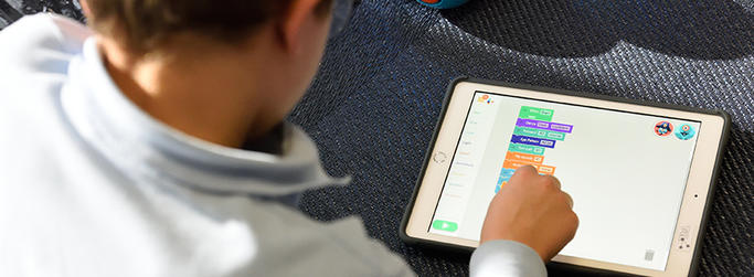 Child coding on tablet