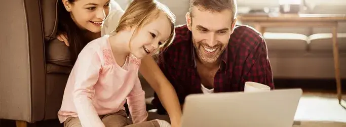 Parents and child enjoying Hughesnet Wi-Fi while watching a video together on a laptop
