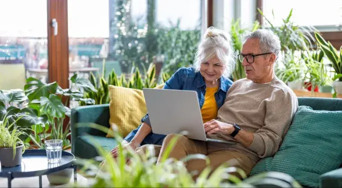An older couple looking at a laptop together 